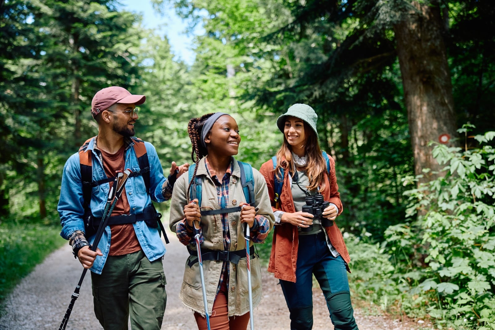 Three friends hiking in a wooded area in Hyde Memorial State Park near Santa Fe, NM.