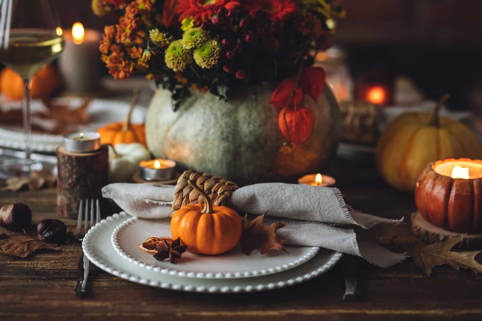 Festive holiday table decor with pumpkins, plates, and flowers for a Santa Fe Thanksgiving.