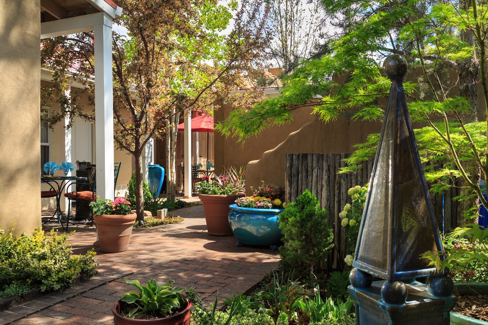 Patio courtyard with large pots and shade trees at Four Kachinas, a Santa Fe, New Mexico bed and breakfast.