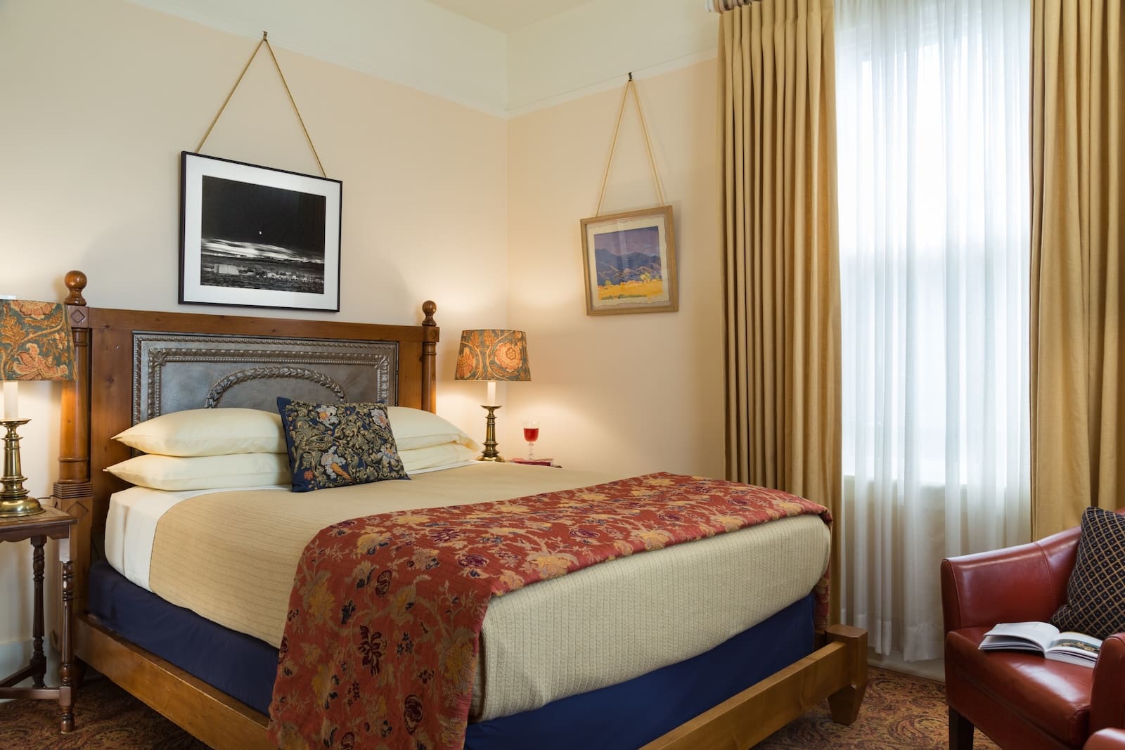 Santa Fe Hiking Trails: The Complete Guide to Local Favorites 5 A guest room with a comfy bed hanging art, lamps, and a window at a Bed and Breakfast in Santa Fe NM.