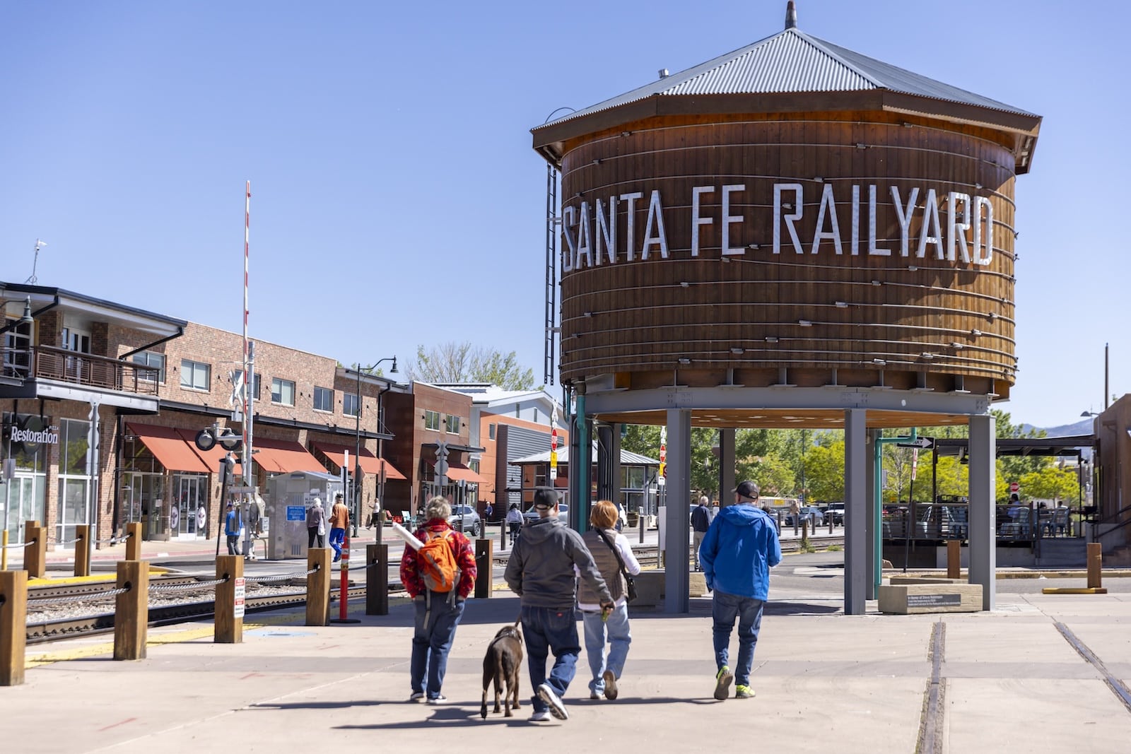 The Best Santa Fe Train Rides 1 Four people and a dog approaching the Santa Fe Railyard where you can find the best Santa Fe trains.