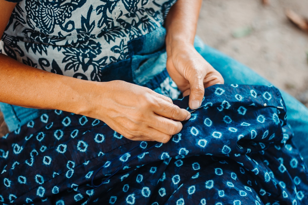 close up of woman sewing tribal fabric, representative of what artistry on display at Museum of International Folk Art on Santa Fe's Museum Hill