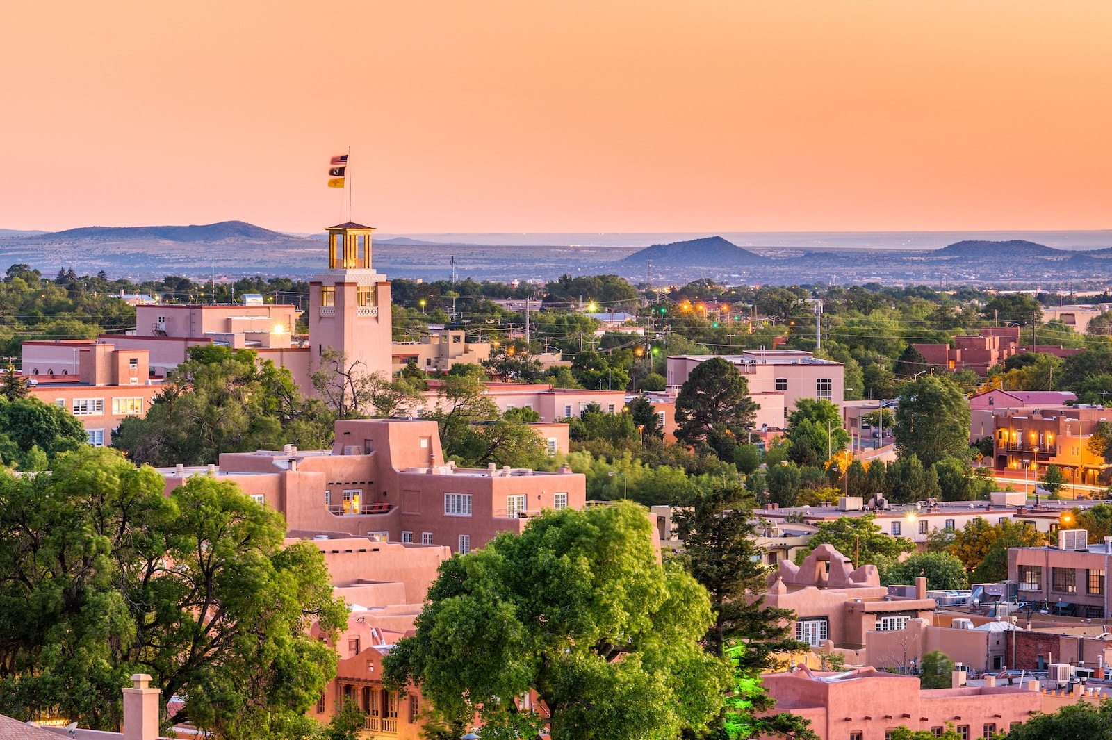 There are many things to do in Santa Fe with kids. It's the perfect city for a family vacation. Image of Santa Fe skyline at dusk.